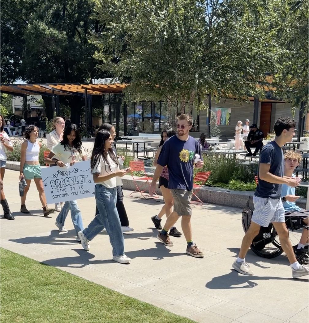 Walking downtown with the Take a Bracelet sign